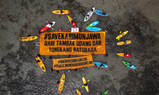 Masyarakat Karimunjawa bersama Greenpeace Indonesia membentangkan spanduk berukuran 5×15 meter bertuliskan Save Karimunjawa di tengah laut dengan menggunakan kayak. (Sumber: Greenpeace Indonesia)